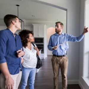 man showing a couple around a home