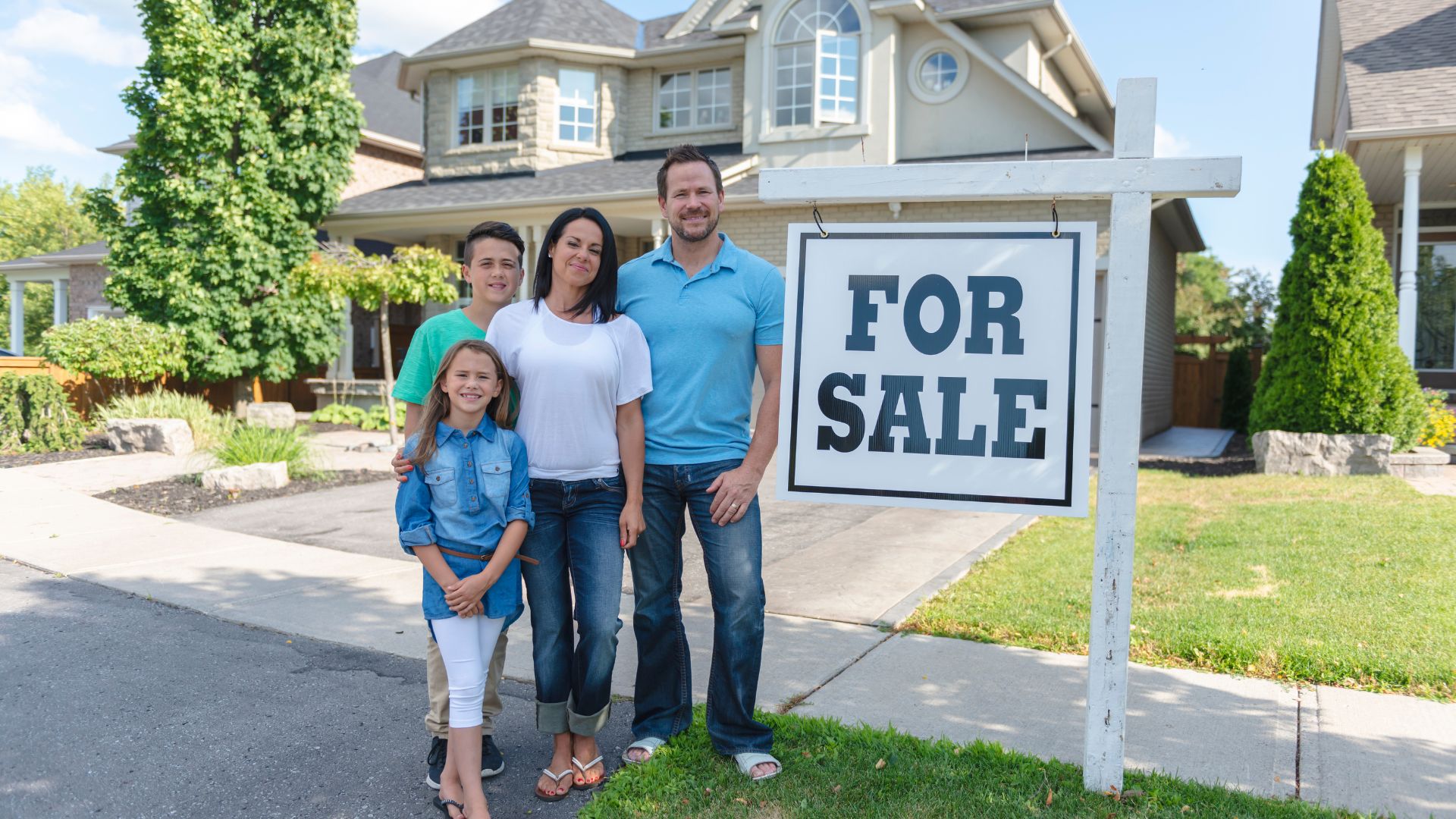 family near a for sale sign