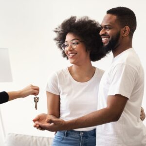 Someone giving couple keys to house