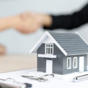 model home in front of shaking hands