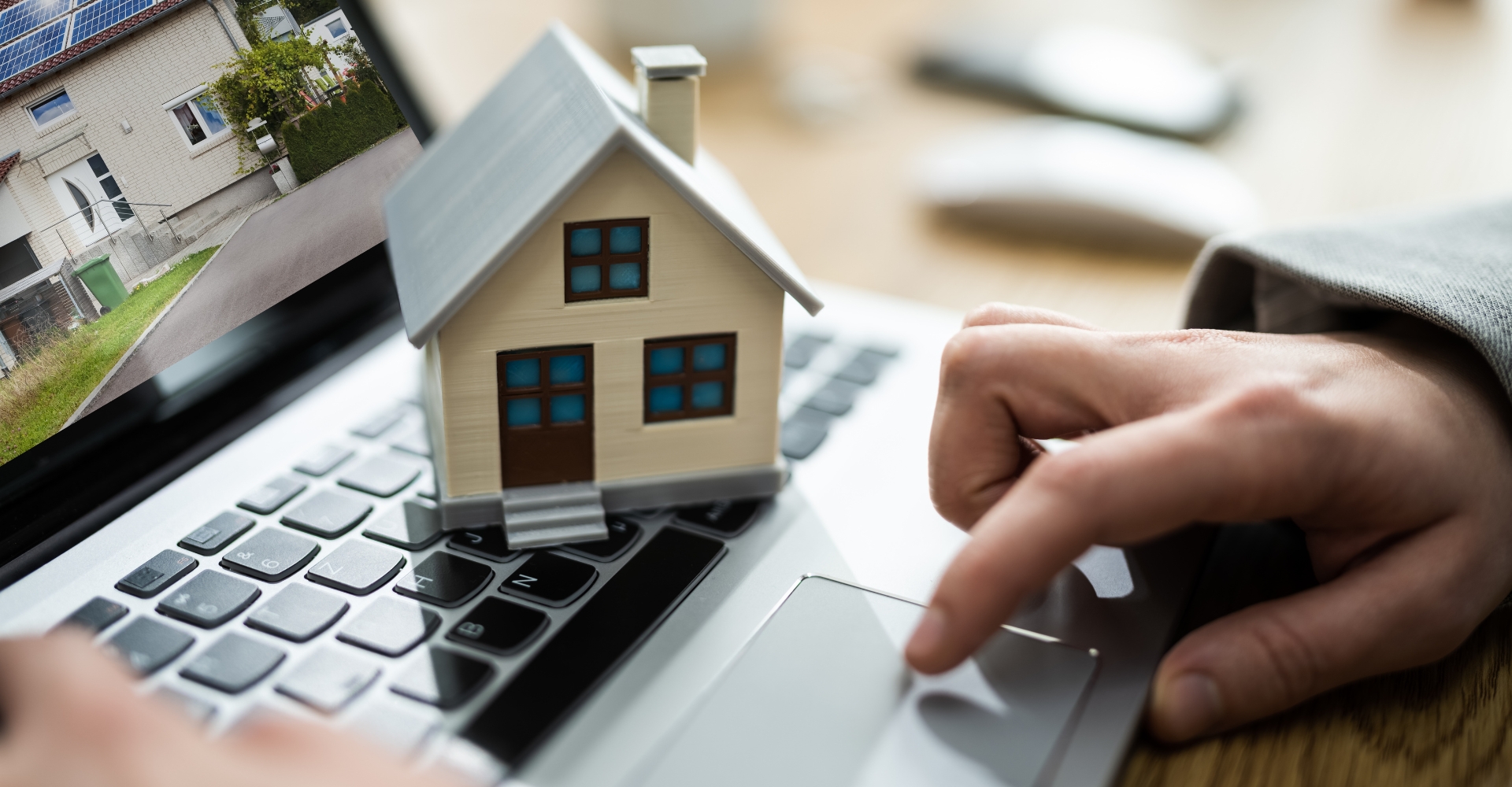hands on a keyboard with a model home