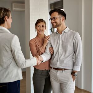 A real estate agent shaking hands with clients
